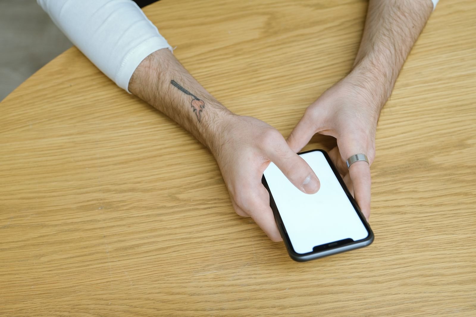 Hands holding a phone with a blank screen