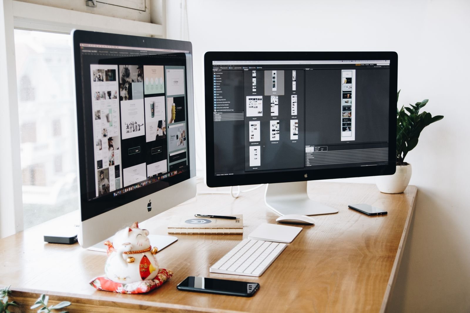 A bright desk with monitors laid out for design work